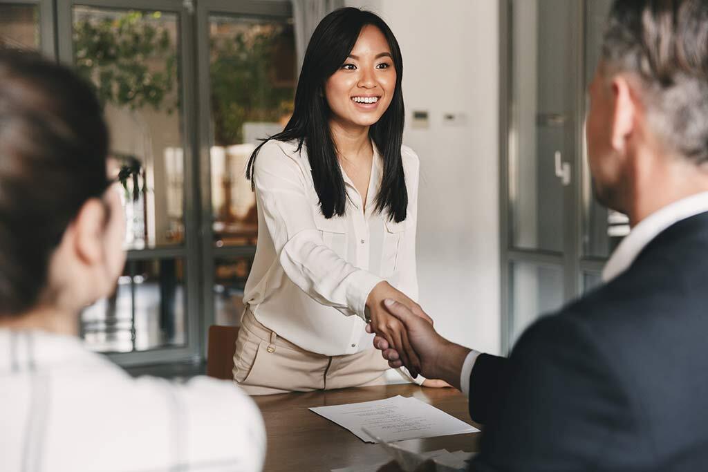 Young woman shaking hands during job interview